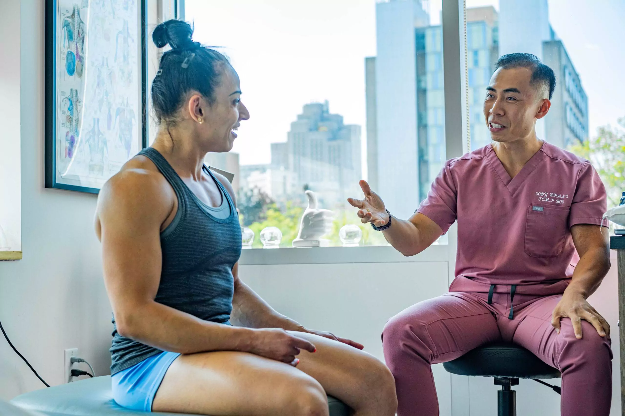 Cody Zhang consulting with elite athlete at BodyOption Clinic in Vancouver