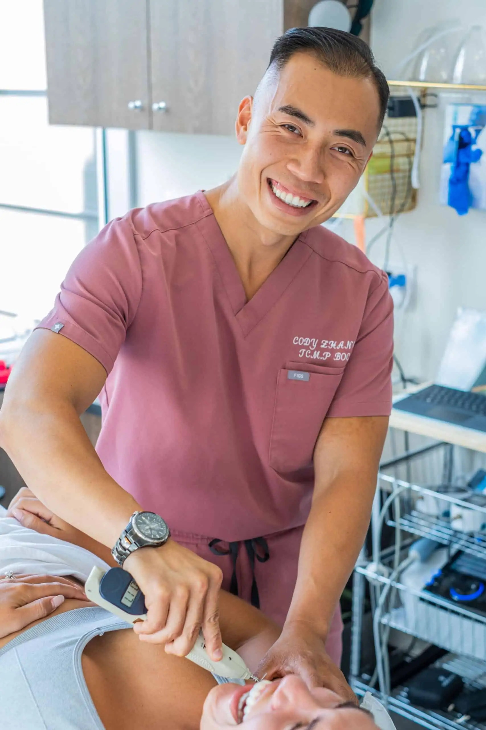 Cody Zhang, Licensed Acupuncturist and TCM Practitioner, performing electro-therapy for shoulder pain at BodyOption Clinic in Vancouver